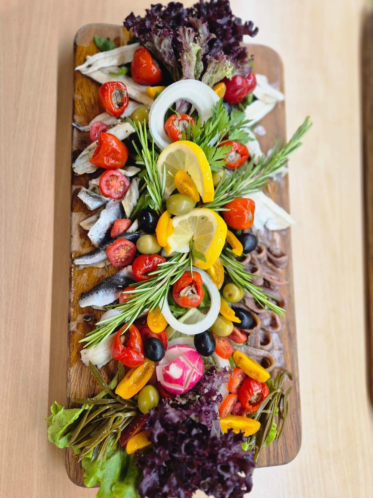 A long board of marinated fish with rosemary and lemon