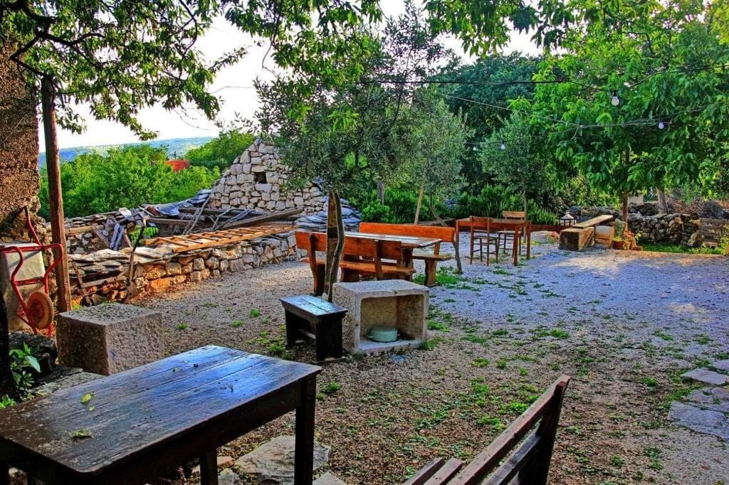 The courtyard — stone walls, wooden tables and benches