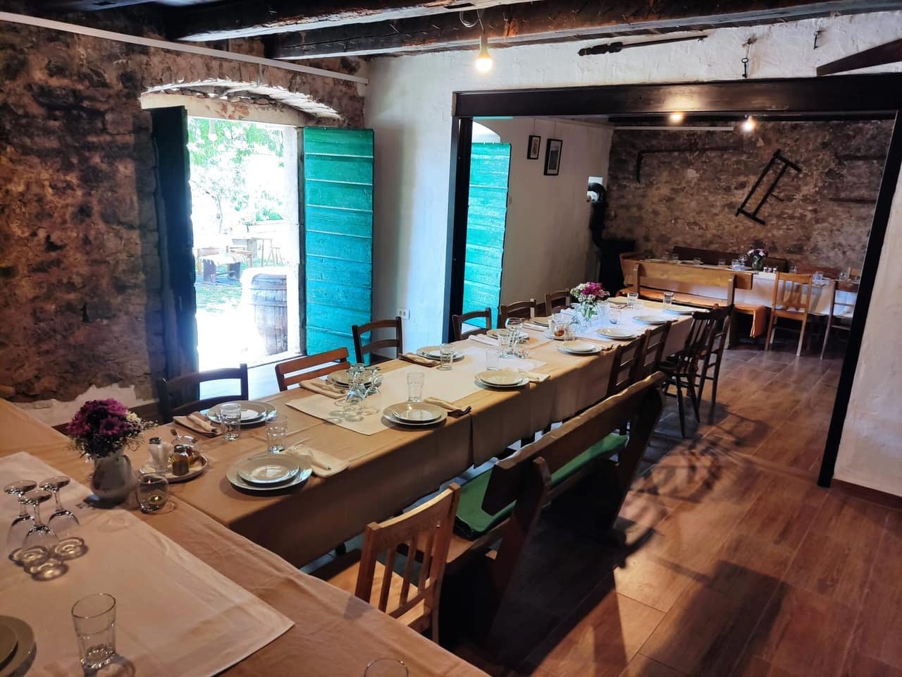 The old stone dining room, the long table set for guests