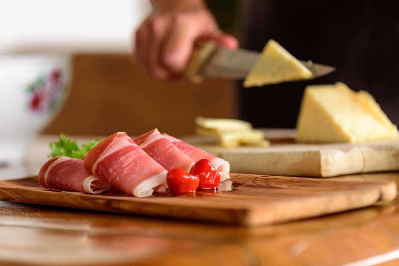 Slicing the cheese — the pršut and cheese for the plata